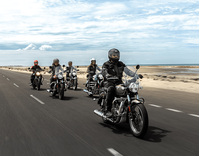 Group of Royal Enfield riders on coastal highway